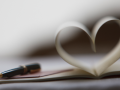 pen and book pages in shape of heart