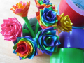 Colorful handmade flowers made from duct tape, arranged like a bouquet next to rolls of tape.