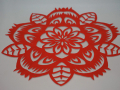 red paper cut into intricate circular design