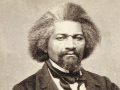 Black and white photo of Frederick Douglass in 19th century suit 