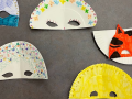 Paper plates decorated as Mardi Gras Masks