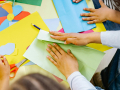 hands folding and cutting colorful paper