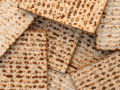 Matzah bread unevenly stacked in a pile.