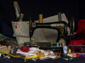A color photo of a vintage sewing machine, surrounded by sewing paraphernalia, Image by andreas N from Pixabay
