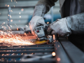 worker with a tool working on an iron beam sparking some fire 