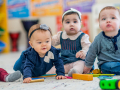 four babies sitting on the floor
