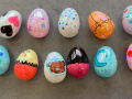 Eleven plastic eggs decorated with marker drawings