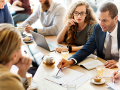  people gathered around a table having a financial discussion