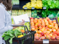Woman shopping in produce aisle of grocery store