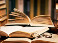 An open book among stacks.