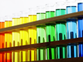A rainbow gradient line of test tubes with liquid inside of them with 2 teal borders