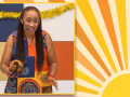 photo of storyteller Ina Buckner-Barnette in a colorful dress, with a colorful picture of sunshine in the background
