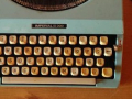 Typewriter and pen sit on a desk