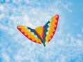 Butterfly shaped kite flying against a blue sky