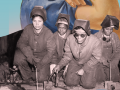 A historical photo group of four female industrial workers looking at the camera while doing their jobs.