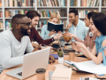 Group of adults meeting with laptops