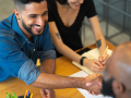 People shaking hands across a table
