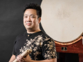 A man stands in front of a Japanese taiko drum