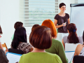 A person presenting in front of several people.