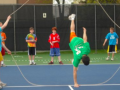 two people holds the jump rope while another one does tricks