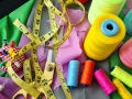 sewing materials. thread various colors, measuring tape, pins, scissors and fabric 