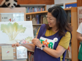 Woman reading a picture book to children in a library
