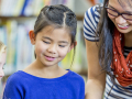 Two children listens to an adult reading to them