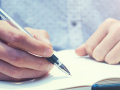 hands on a journal poised to write
